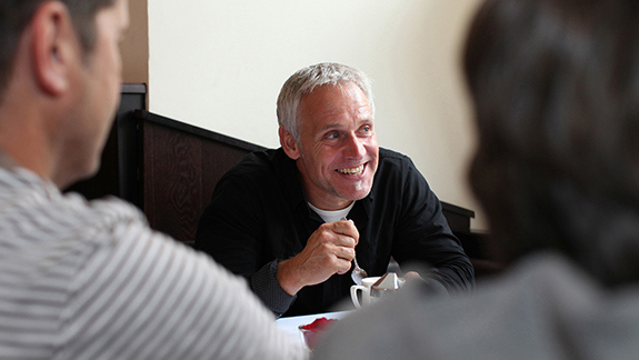 man-having-coffee-with-friends-intermittent-catheterization-techniques_575x325